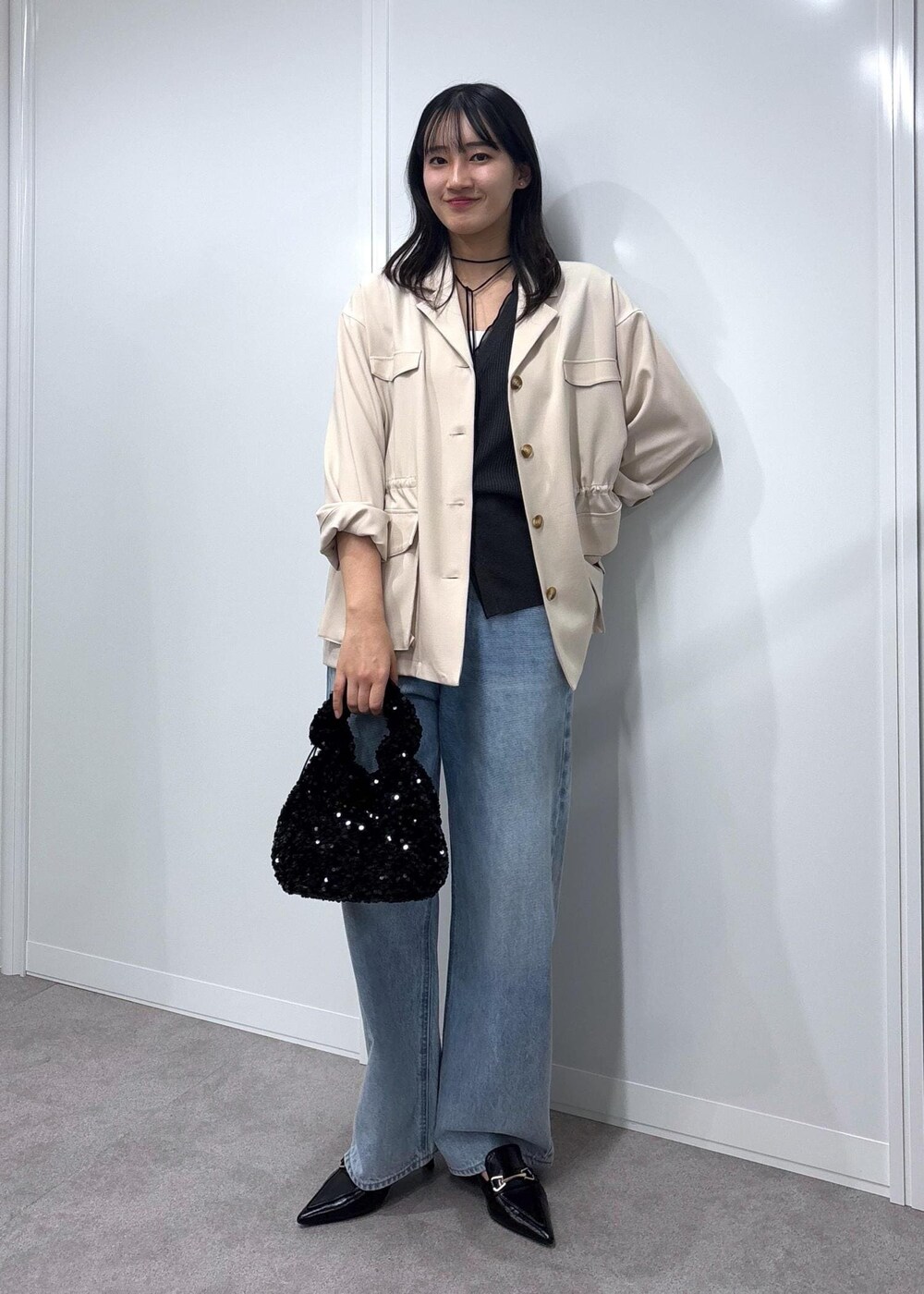 ブルー系のデニムパンツ、ブラック系のパンプス、ホワイト系のミリタリージャケットを着用したレディースの春コーディネートの8枚目の写真