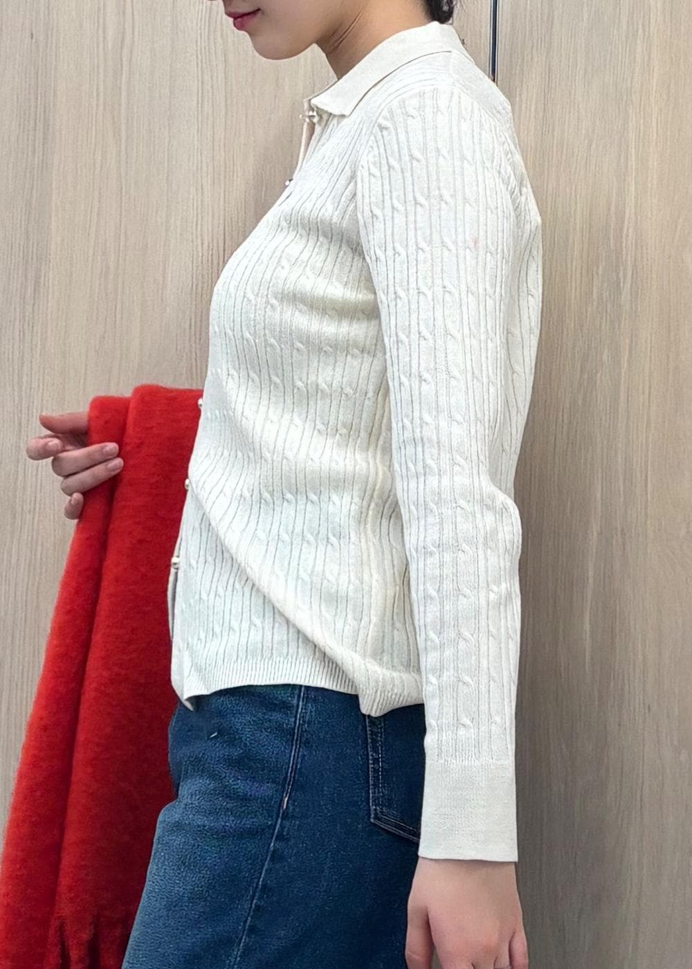 ブルー系のデニムパンツ、ブラック系のハンドバッグ、ホワイト系のカーディガン/ボレロを着用したレディースの冬コーディネートの5枚目の写真