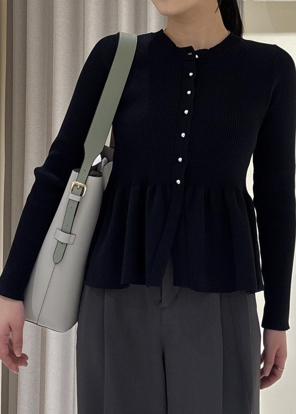 グレー系のトートバッグ、ブラック系のパンプス、ブルー系のカーディガン/ボレロを着用したレディースの春コーディネートの9枚目の写真