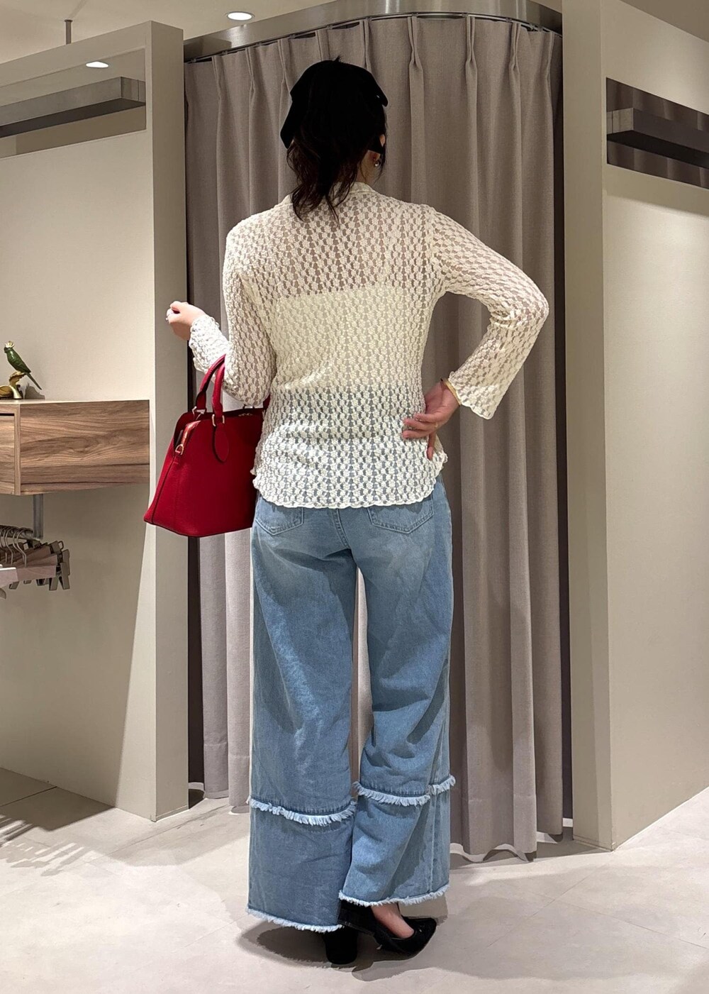 ブルー系のデニムパンツ、ブラック系のパンプス、ホワイト系のカーディガン/ボレロを着用したレディースの秋コーディネートの6枚目の写真