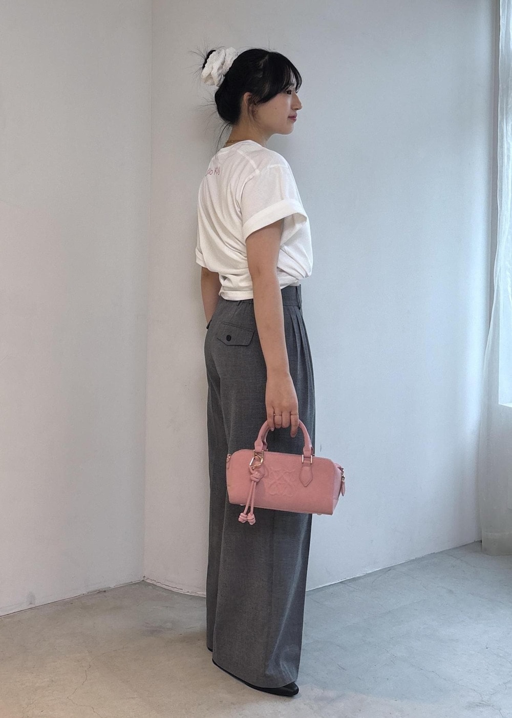 ピンク系のボストンバッグ、ブラック系のパンプス、ホワイト系のTシャツ/カットソーを着用したレディースの夏コーディネートの3枚目の写真