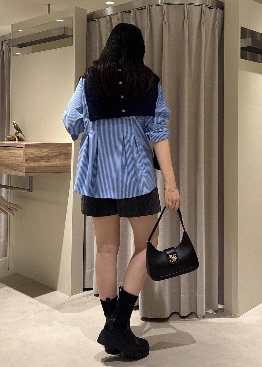 ブラック系のショルダーバッグ、ブラック系のブーツ、グレー系のその他パンツを着用したレディースの秋コーディネートの5枚目の写真