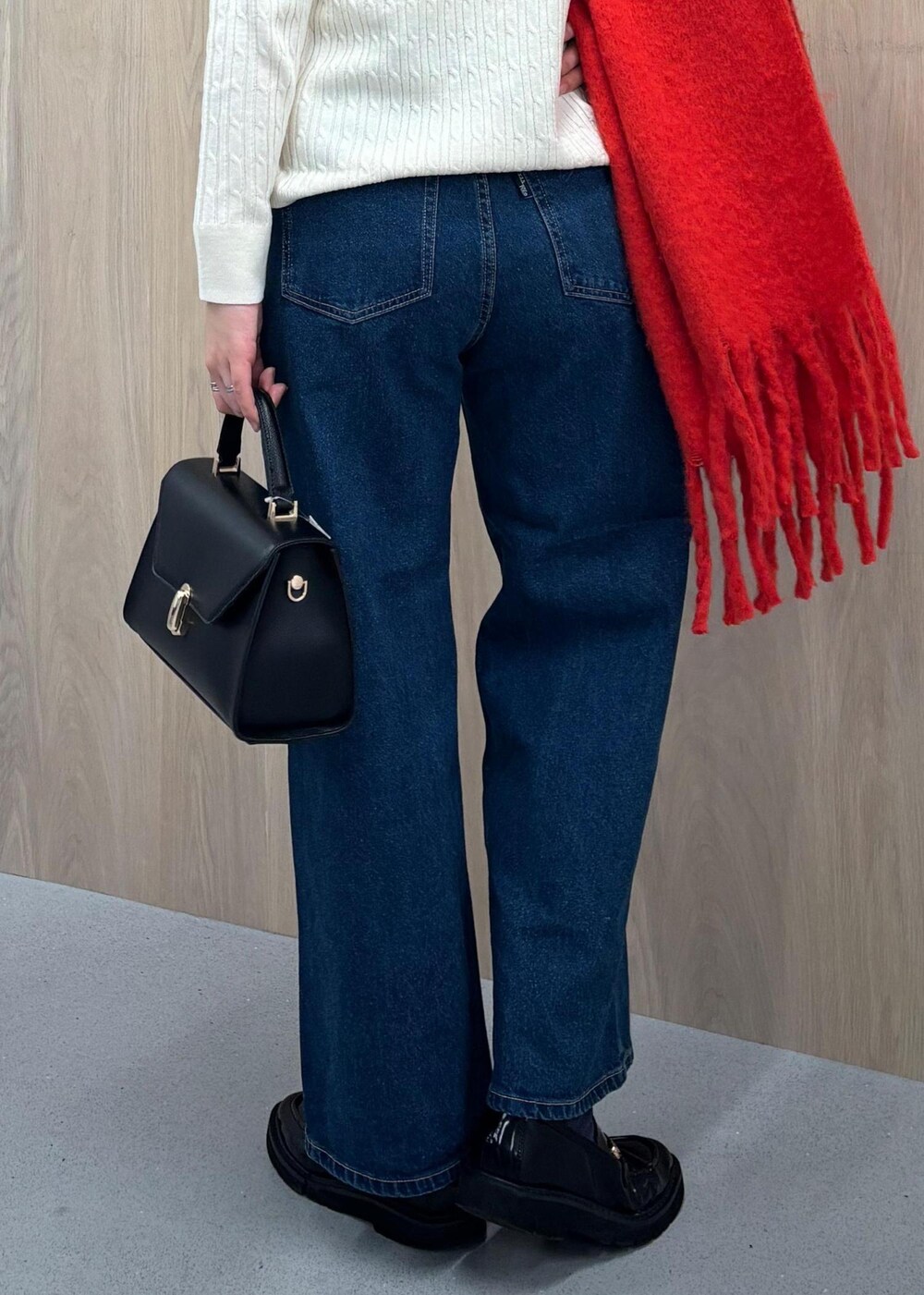 ブルー系のデニムパンツ、ブラック系のハンドバッグ、ホワイト系のカーディガン/ボレロを着用したレディースの冬コーディネートの7枚目の写真