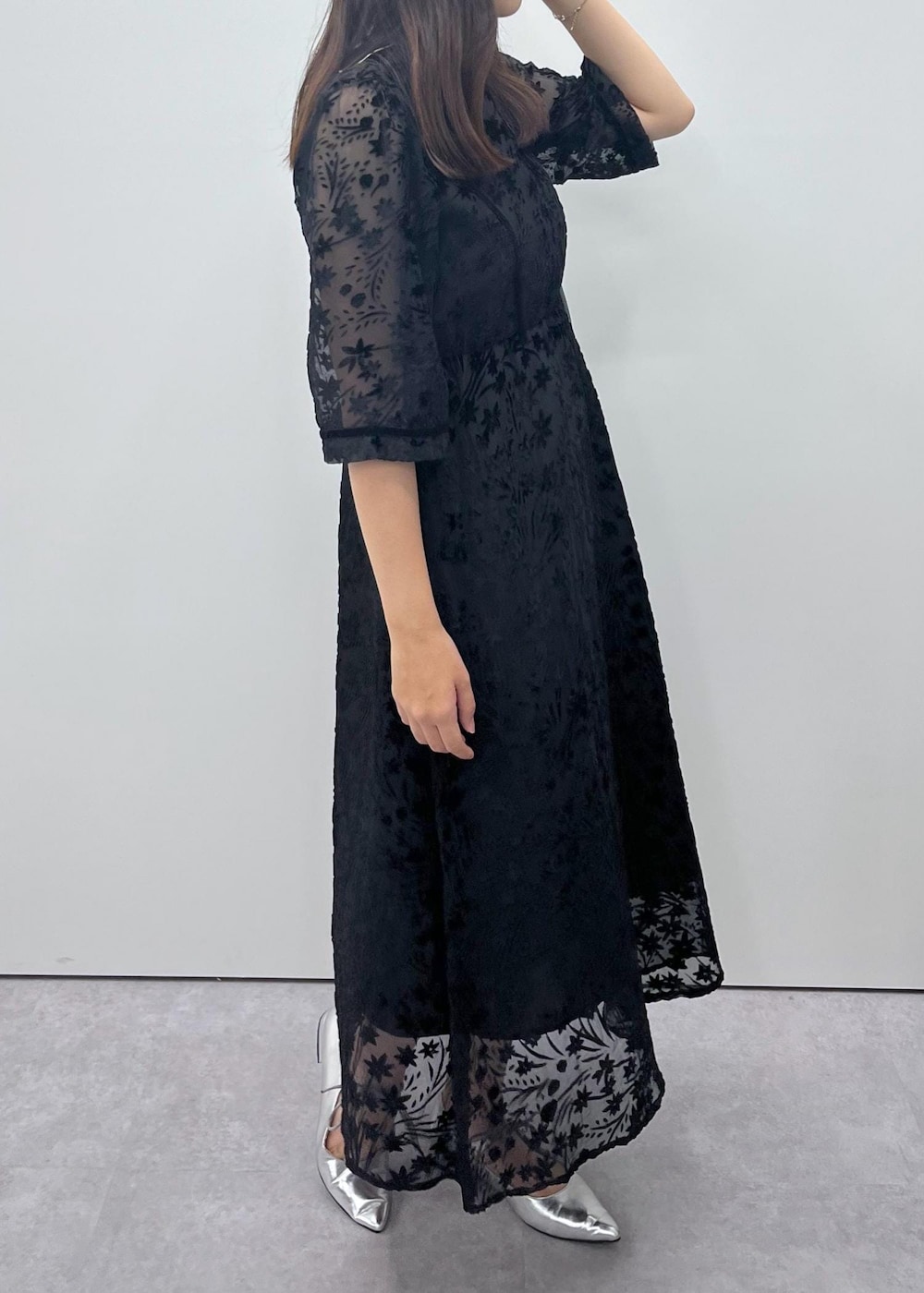 シルバー系のパンプス、グリーン系のショルダーバッグ、ブラック系のドレスを着用したレディースの秋コーディネートの4枚目の写真