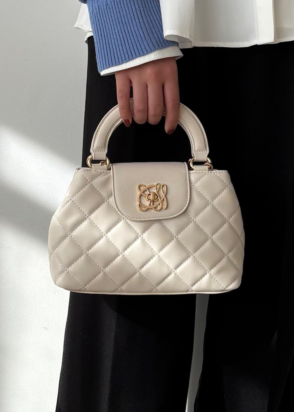 ブルー系のカーディガン/ボレロ、ホワイト系のシャツ/ブラウス、ブルー系のスラックスを着用したレディースの冬コーディネートの8枚目の写真