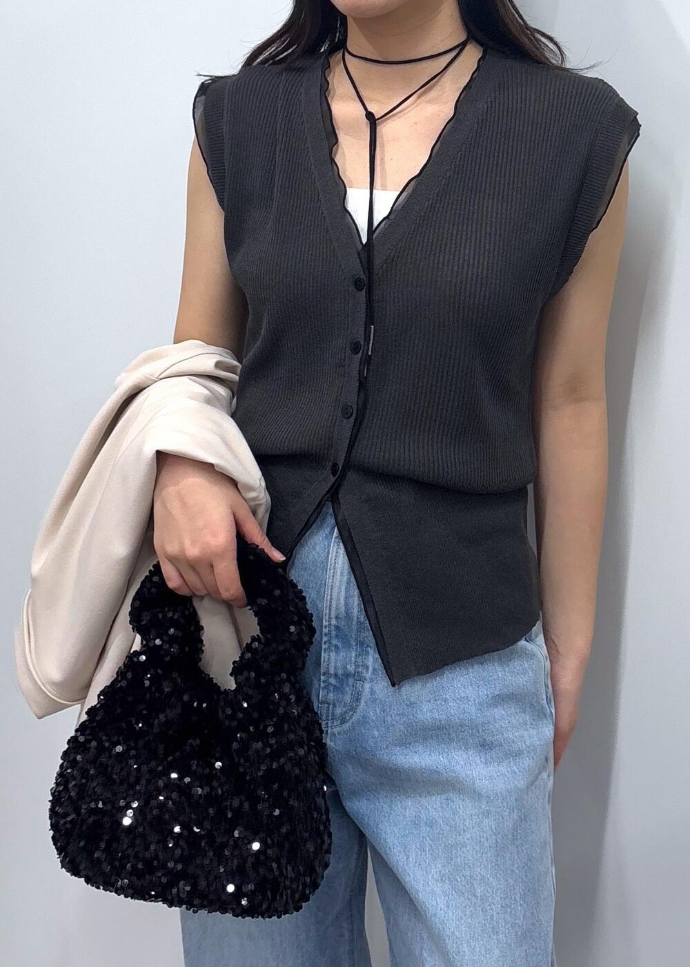 ブルー系のデニムパンツ、ブラック系のパンプス、ホワイト系のミリタリージャケットを着用したレディースの春コーディネートの5枚目の写真