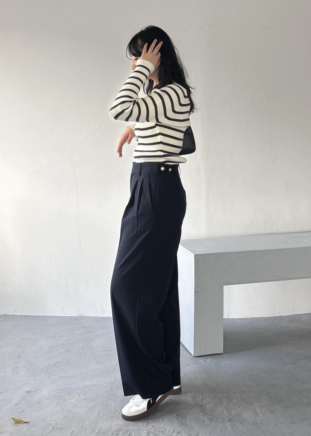 ブラック系のショルダーバッグ、ホワイト系のニット/セーター、ブルー系のその他パンツを着用したレディースの冬コーディネートの4枚目の写真