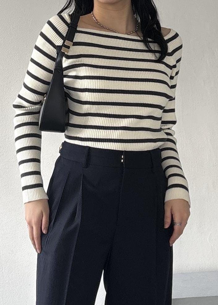 ブラック系のショルダーバッグ、ホワイト系のニット/セーター、ブルー系のその他パンツを着用したレディースの冬コーディネートの6枚目の写真