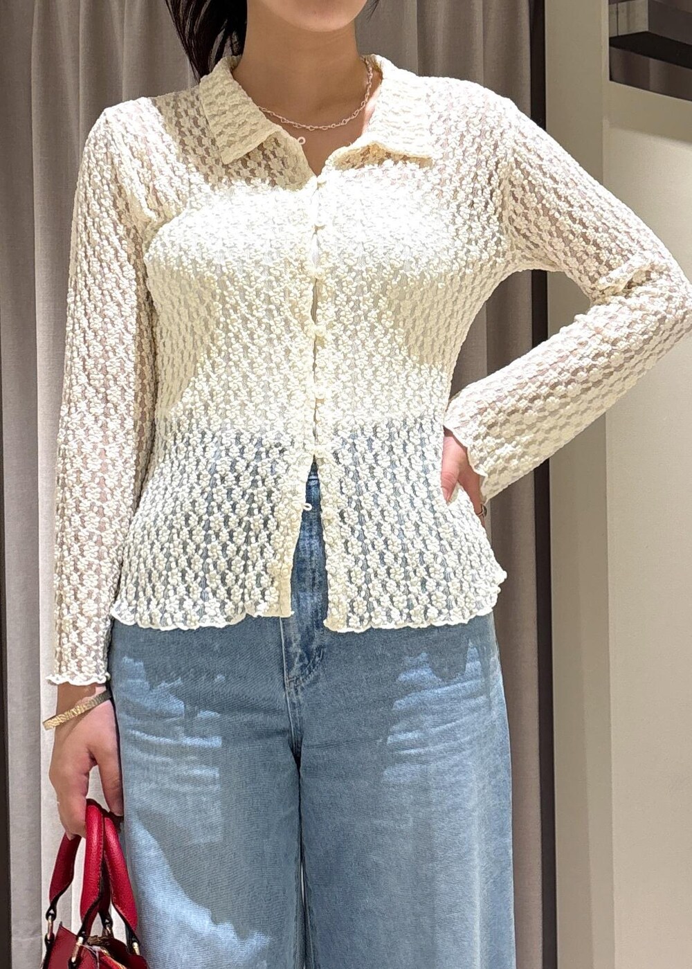 ブルー系のデニムパンツ、ブラック系のパンプス、ホワイト系のカーディガン/ボレロを着用したレディースの秋コーディネートの3枚目の写真