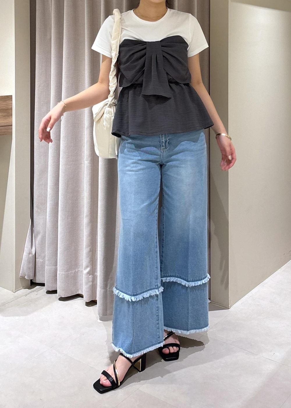 ブラック系のサンダル、ブルー系のデニムパンツ、グレー系のTシャツ/カットソーを着用したレディースの夏コーディネートの7枚目の写真