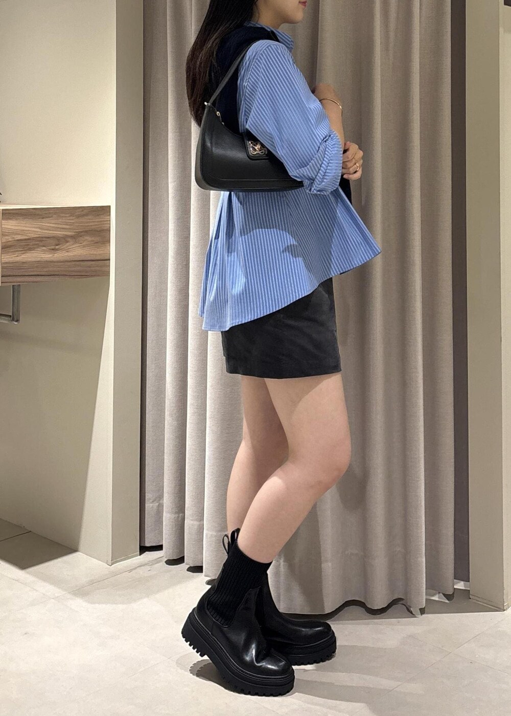 ブラック系のショルダーバッグ、ブラック系のブーツ、グレー系のその他パンツを着用したレディースの秋コーディネートの6枚目の写真