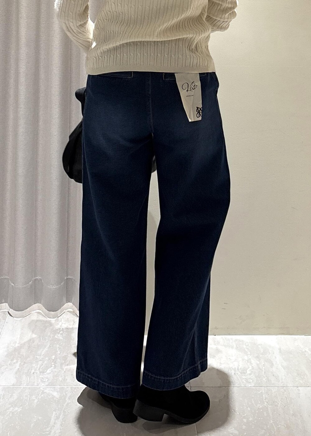 ホワイト系のキャミソール、ホワイト系のカーディガン/ボレロ、ブルー系のデニムパンツを着用したレディースの冬コーディネートの8枚目の写真