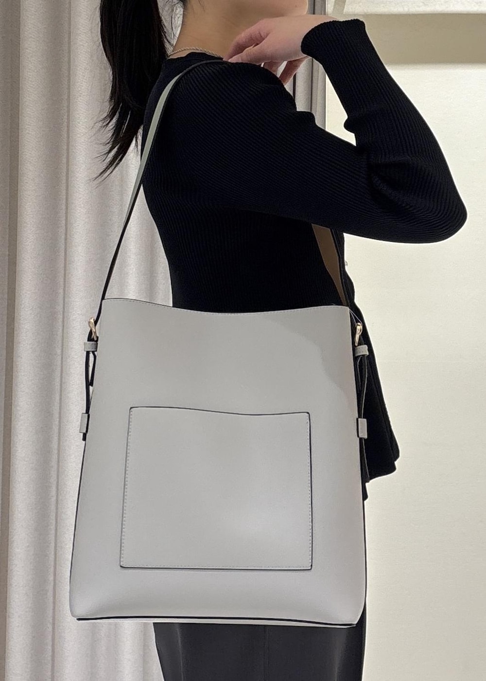 グレー系のトートバッグ、ブラック系のパンプス、ブルー系のカーディガン/ボレロを着用したレディースの春コーディネートの7枚目の写真