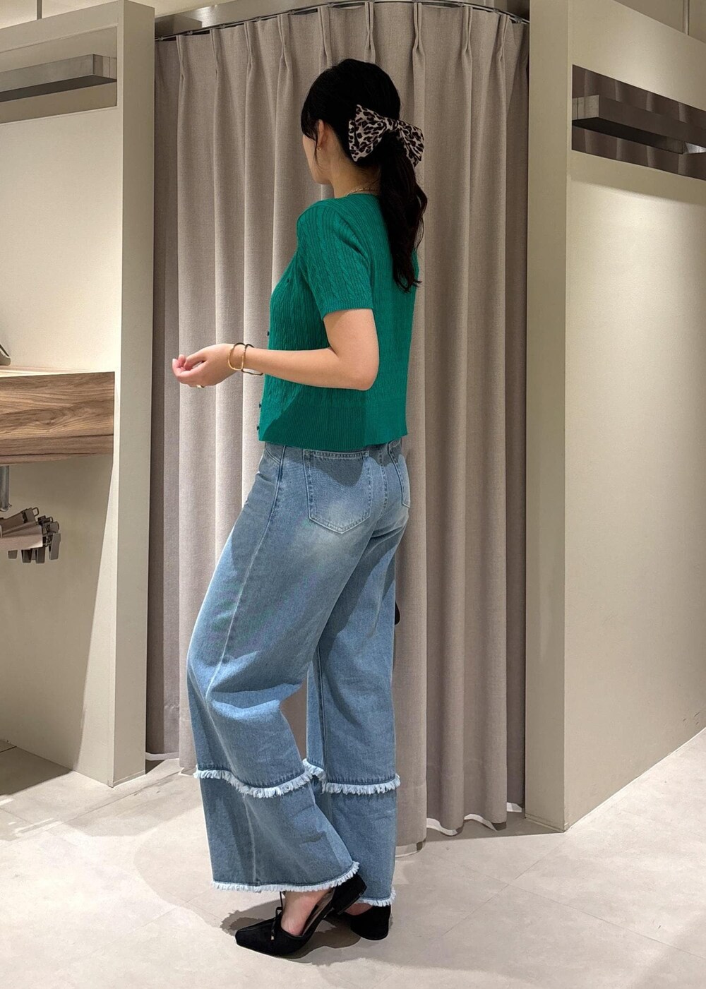 ブラック系のショルダーバッグ、グリーン系のカーディガン/ボレロ、ブルー系のデニムパンツを着用したレディースの秋コーディネートの5枚目の写真