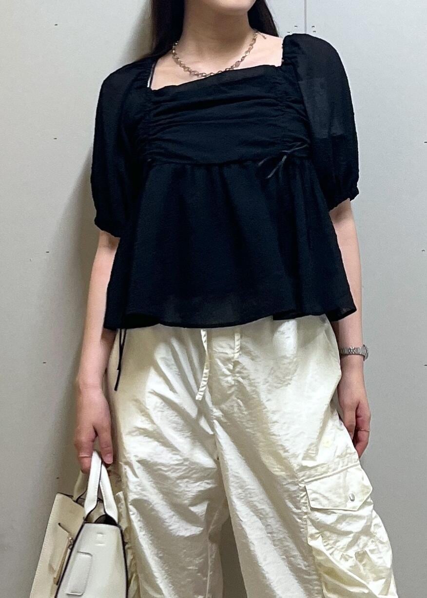 シルバー系のパンプス、ホワイト系のハンドバッグ、ホワイト系のキャミソールを着用したレディースの夏コーディネートの3枚目の写真