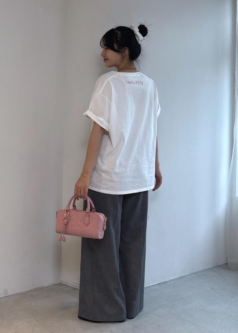 ピンク系のボストンバッグ、ブラック系のパンプス、ホワイト系のTシャツ/カットソーを着用したレディースの夏コーディネートの5枚目の写真