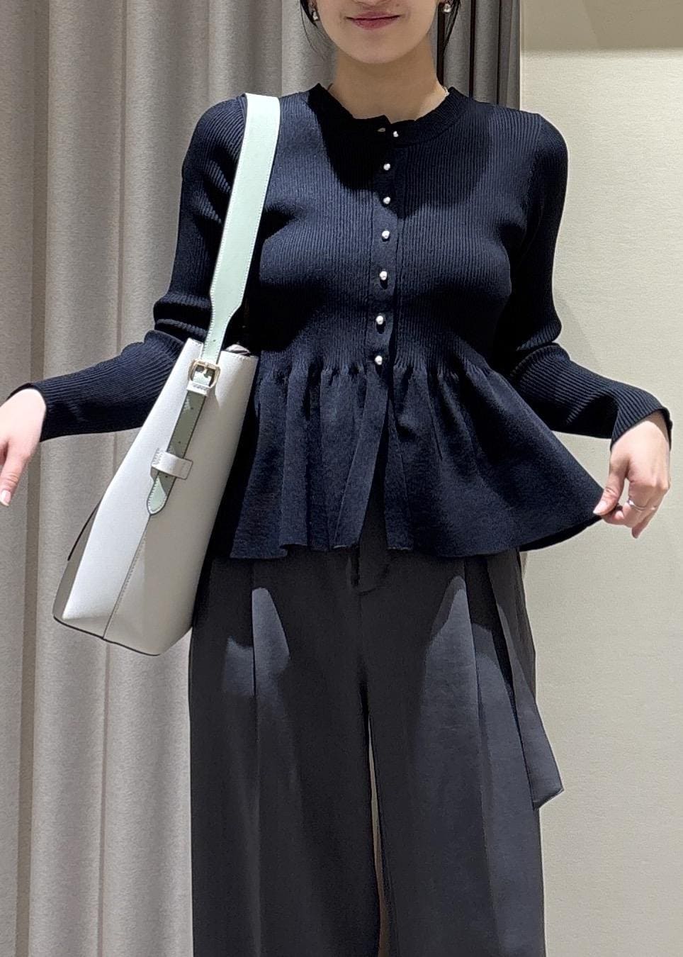 グレー系のトートバッグ、ブラック系のパンプス、ブルー系のカーディガン/ボレロを着用したレディースの春コーディネートの5枚目の写真