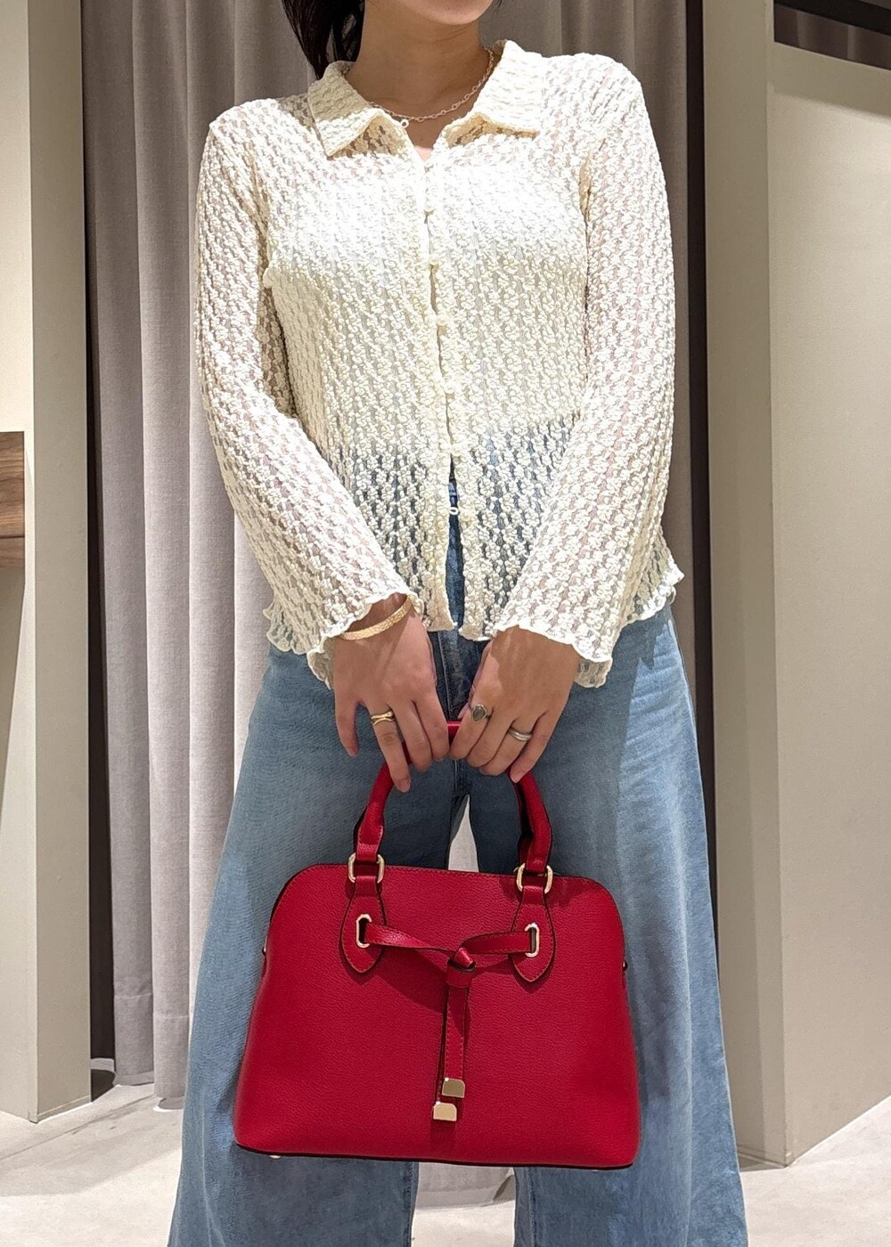 ブルー系のデニムパンツ、ブラック系のパンプス、ホワイト系のカーディガン/ボレロを着用したレディースの秋コーディネートの4枚目の写真