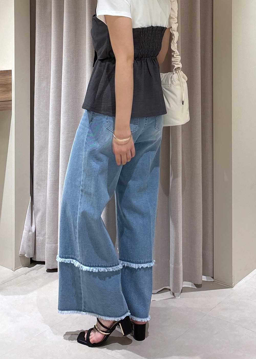 ブラック系のサンダル、ブルー系のデニムパンツ、グレー系のTシャツ/カットソーを着用したレディースの夏コーディネートの6枚目の写真