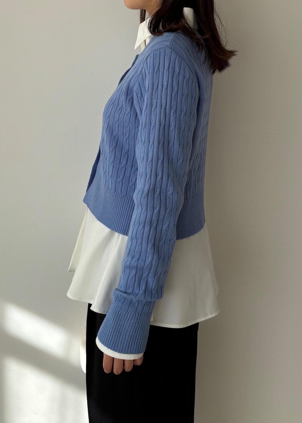 ブルー系のカーディガン/ボレロ、ホワイト系のシャツ/ブラウス、ブルー系のスラックスを着用したレディースの冬コーディネートの3枚目の写真