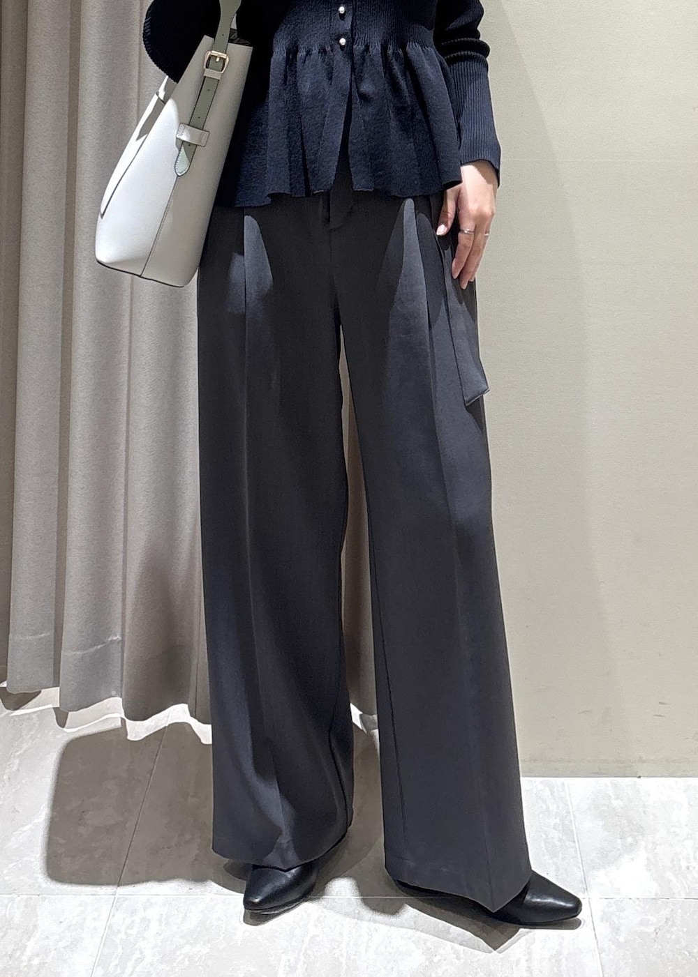 グレー系のトートバッグ、ブラック系のパンプス、ブルー系のカーディガン/ボレロを着用したレディースの春コーディネートの6枚目の写真