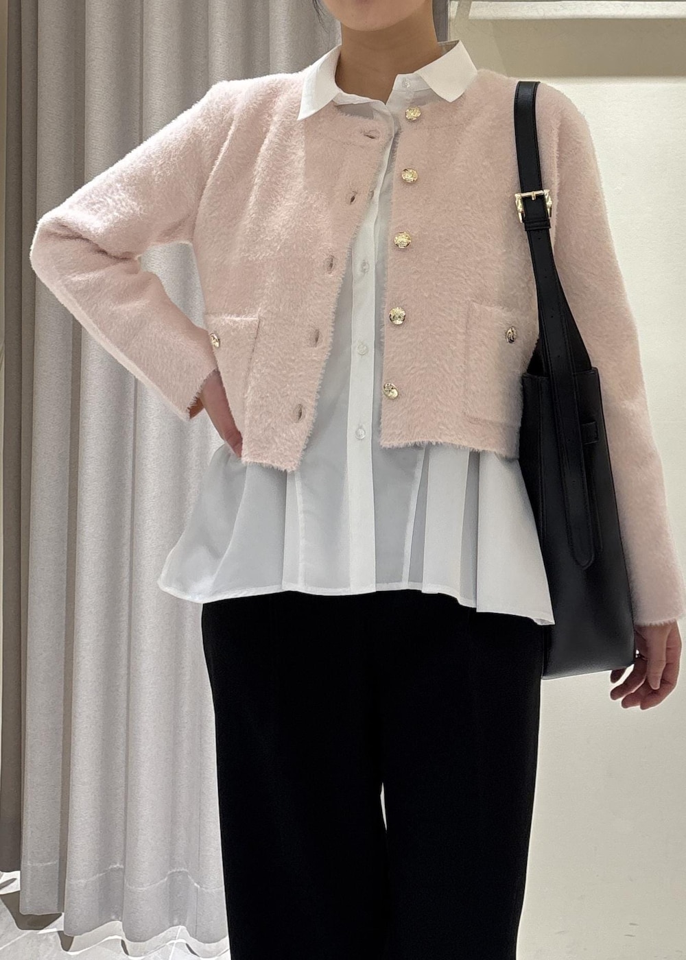 ホワイト系のシャツ/ブラウス、ピンク系のカーディガン/ボレロ、ブラック系のスラックスを着用したレディースの冬コーディネートの2枚目の写真