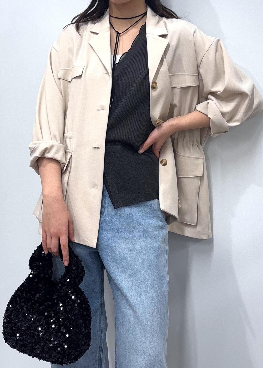 ブルー系のデニムパンツ、ブラック系のパンプス、ホワイト系のミリタリージャケットを着用したレディースの春コーディネートの2枚目の写真