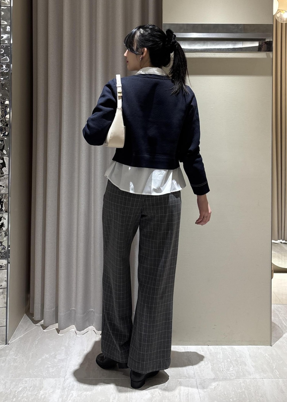 グレー系のその他パンツ、ホワイト系のショルダーバッグ、ブラック系のローファーを着用したレディースの冬コーディネートの6枚目の写真