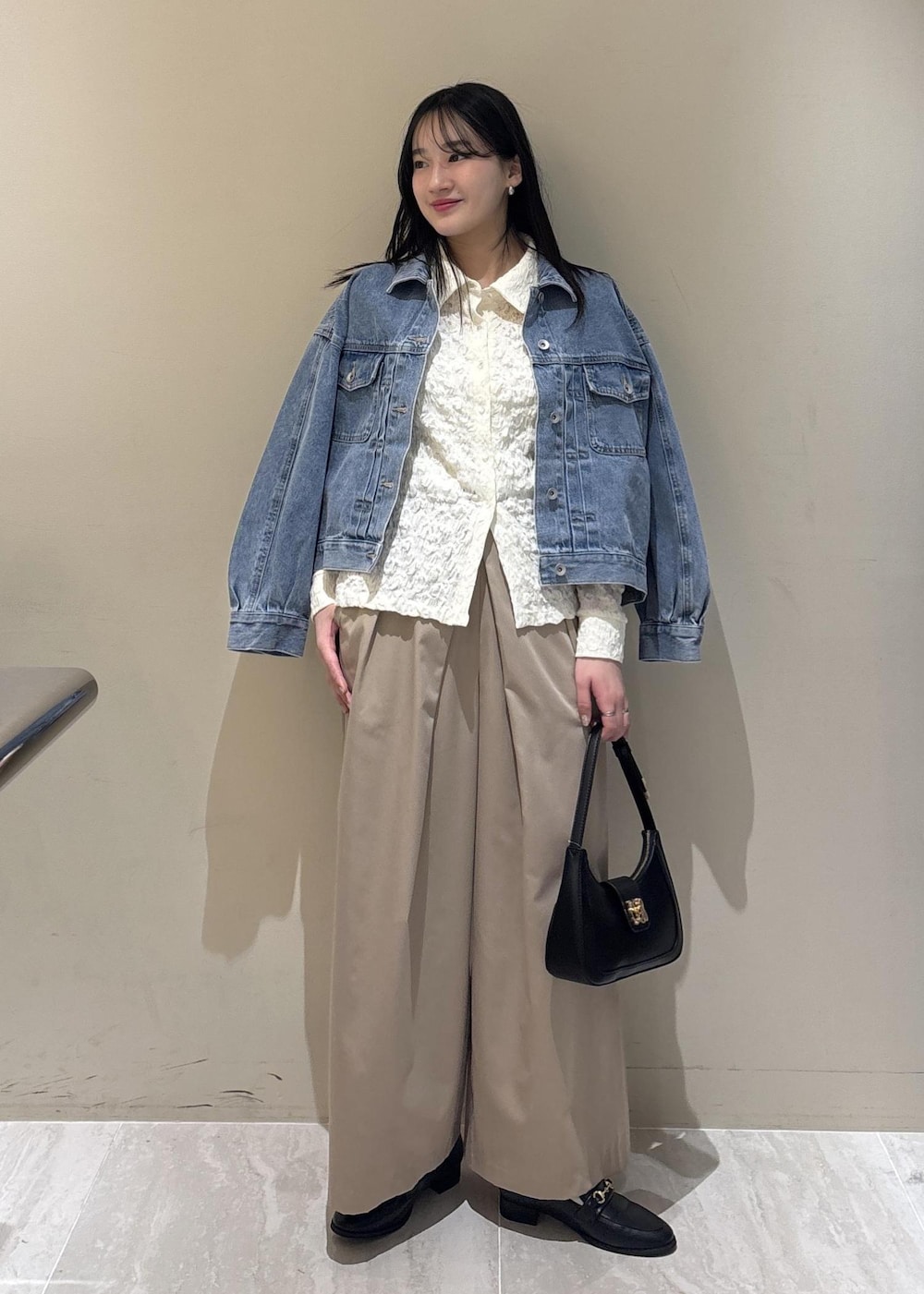 ブラック系のショルダーバッグ、ブラック系のローファー、ホワイト系のシャツ/ブラウスを着用したレディースの冬コーディネートの3枚目の写真