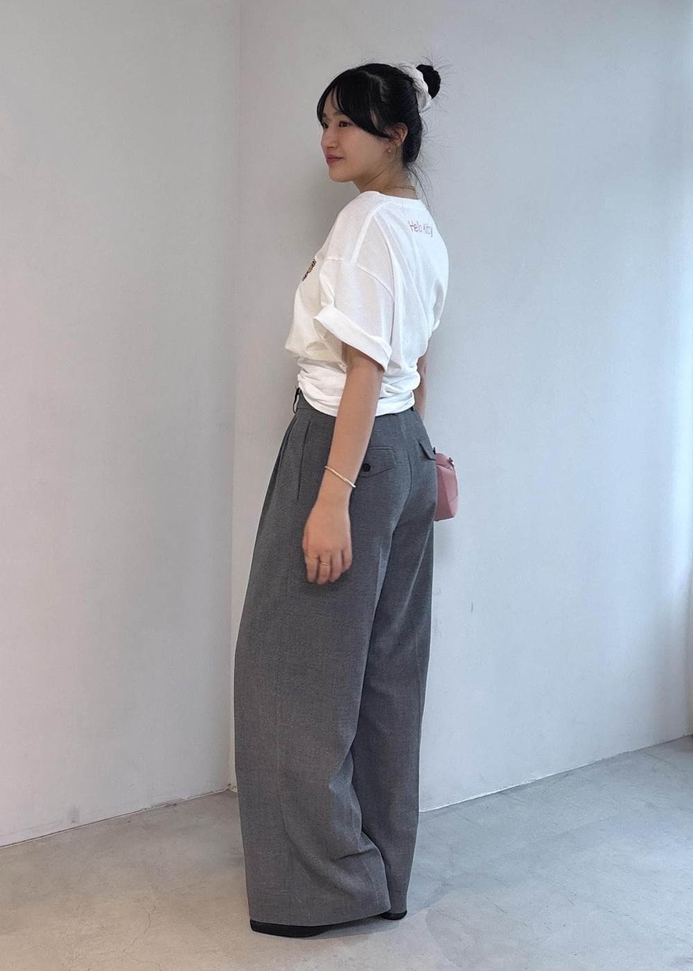 ピンク系のボストンバッグ、ブラック系のパンプス、ホワイト系のTシャツ/カットソーを着用したレディースの夏コーディネートの2枚目の写真
