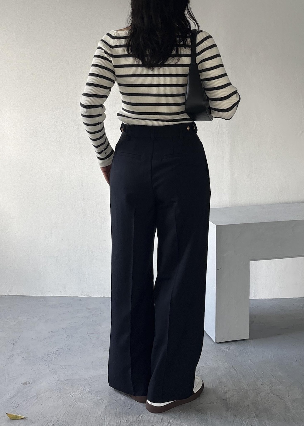 ブラック系のショルダーバッグ、ホワイト系のニット/セーター、ブルー系のその他パンツを着用したレディースの冬コーディネートの3枚目の写真