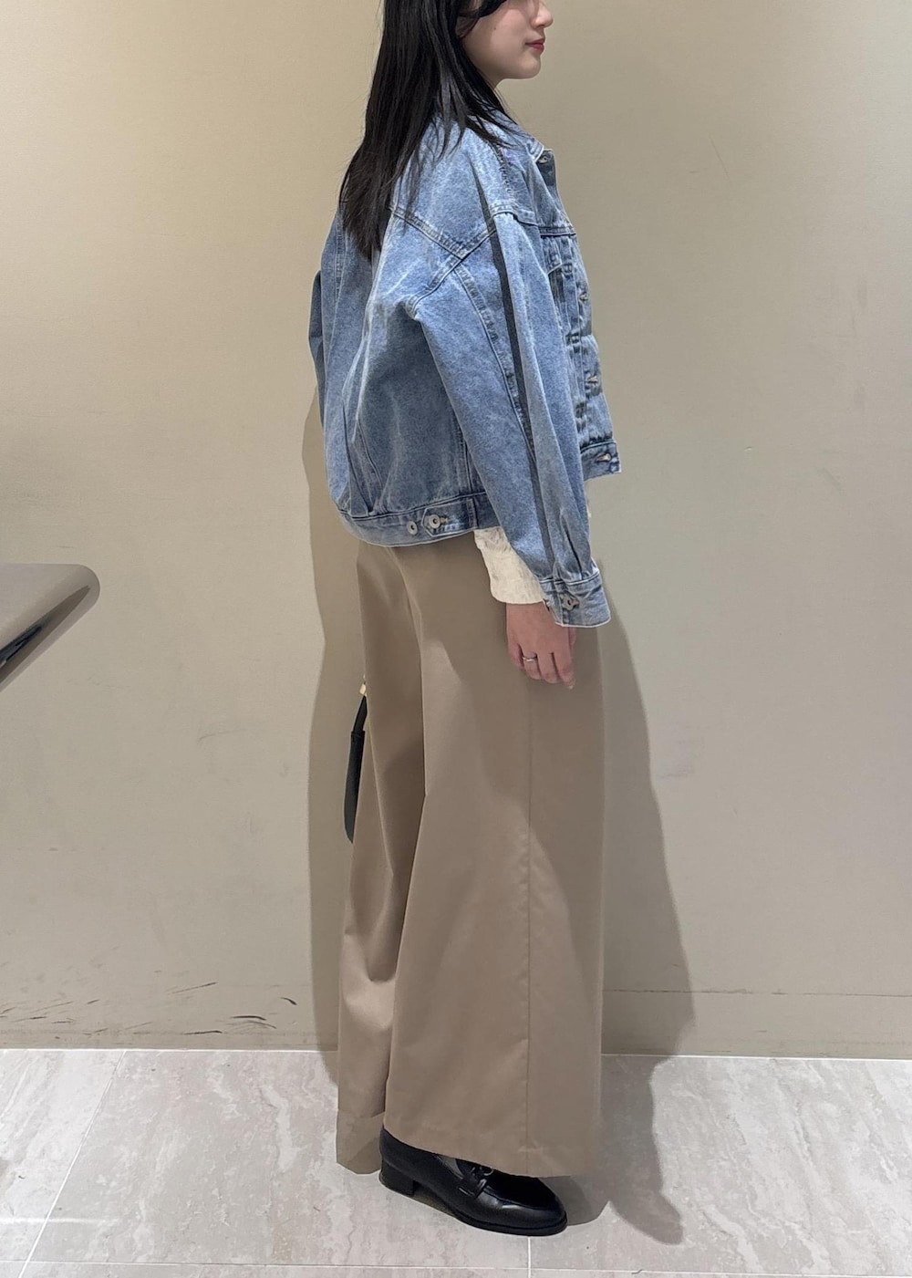 ブラック系のショルダーバッグ、ブラック系のローファー、ホワイト系のシャツ/ブラウスを着用したレディースの冬コーディネートの4枚目の写真