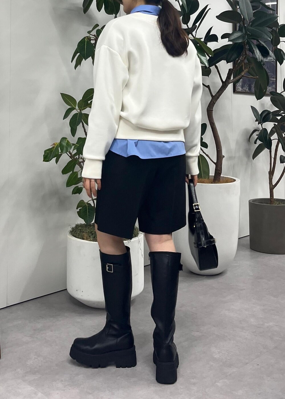 ブラック系のブーツ、ブルー系のシャツ/ブラウス、ホワイト系のその他トップスを着用したレディースの冬コーディネートの6枚目の写真