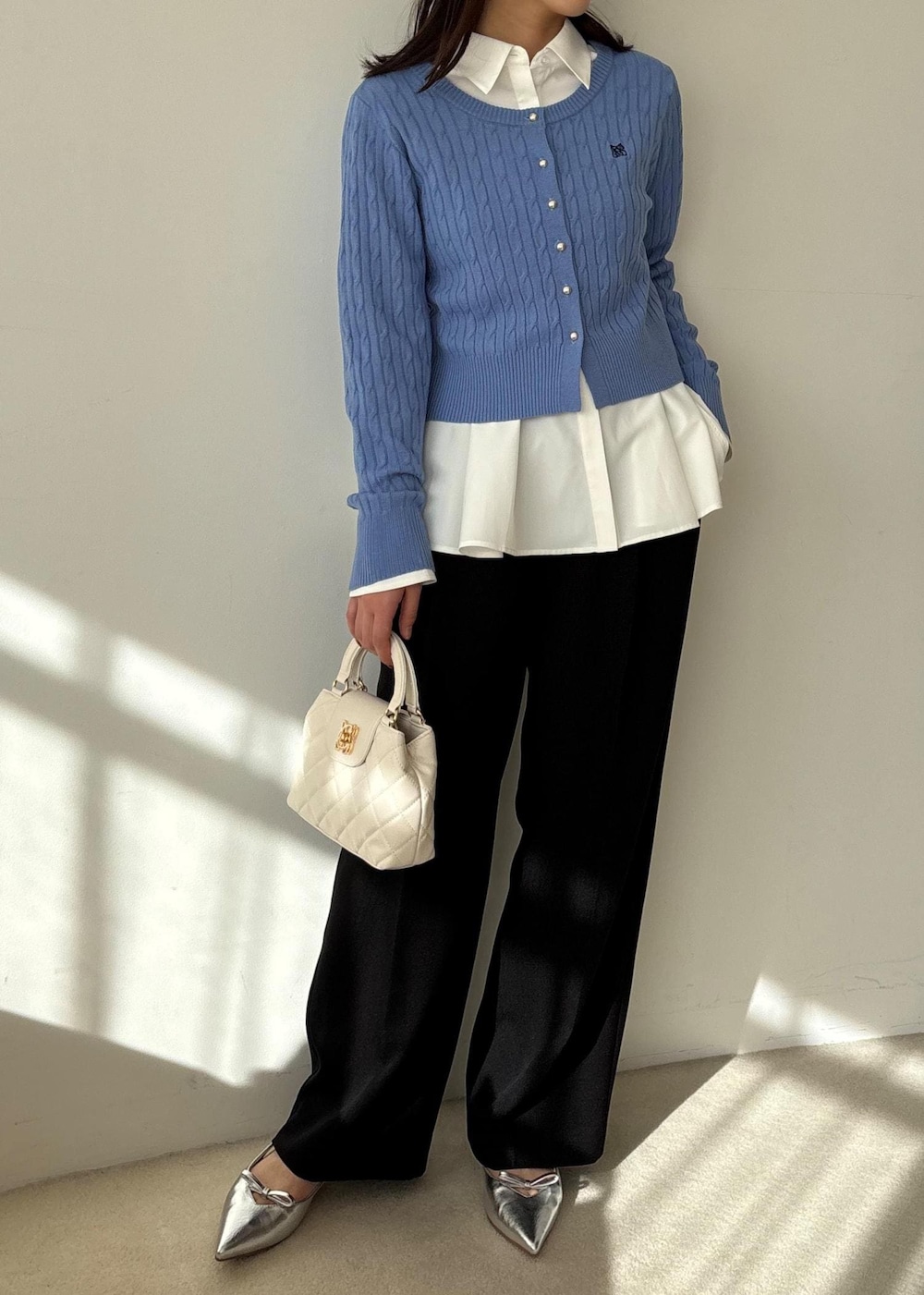 ブルー系のカーディガン/ボレロ、ホワイト系のシャツ/ブラウス、ブルー系のスラックスを着用したレディースの冬コーディネートの5枚目の写真