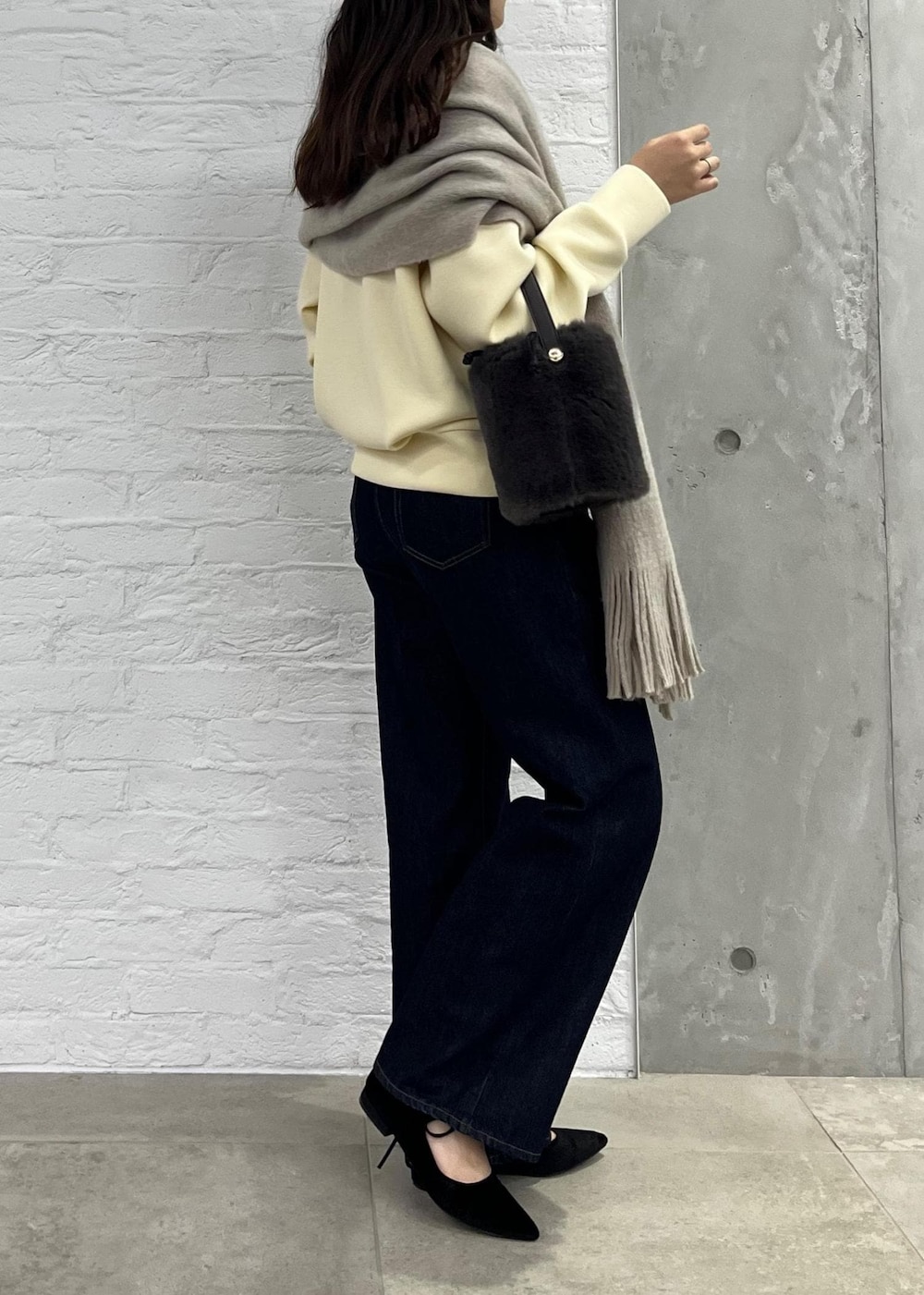 ブルー系のデニムパンツ、グレー系のショルダーバッグ、ベージュ系のその他トップスを着用したレディースの秋コーディネートの4枚目の写真