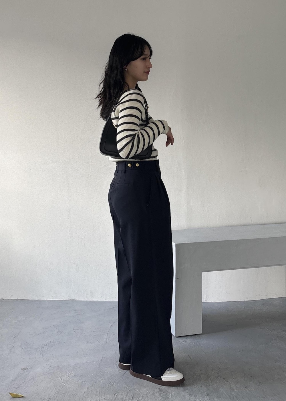 ブラック系のショルダーバッグ、ホワイト系のニット/セーター、ブルー系のその他パンツを着用したレディースの冬コーディネートの2枚目の写真