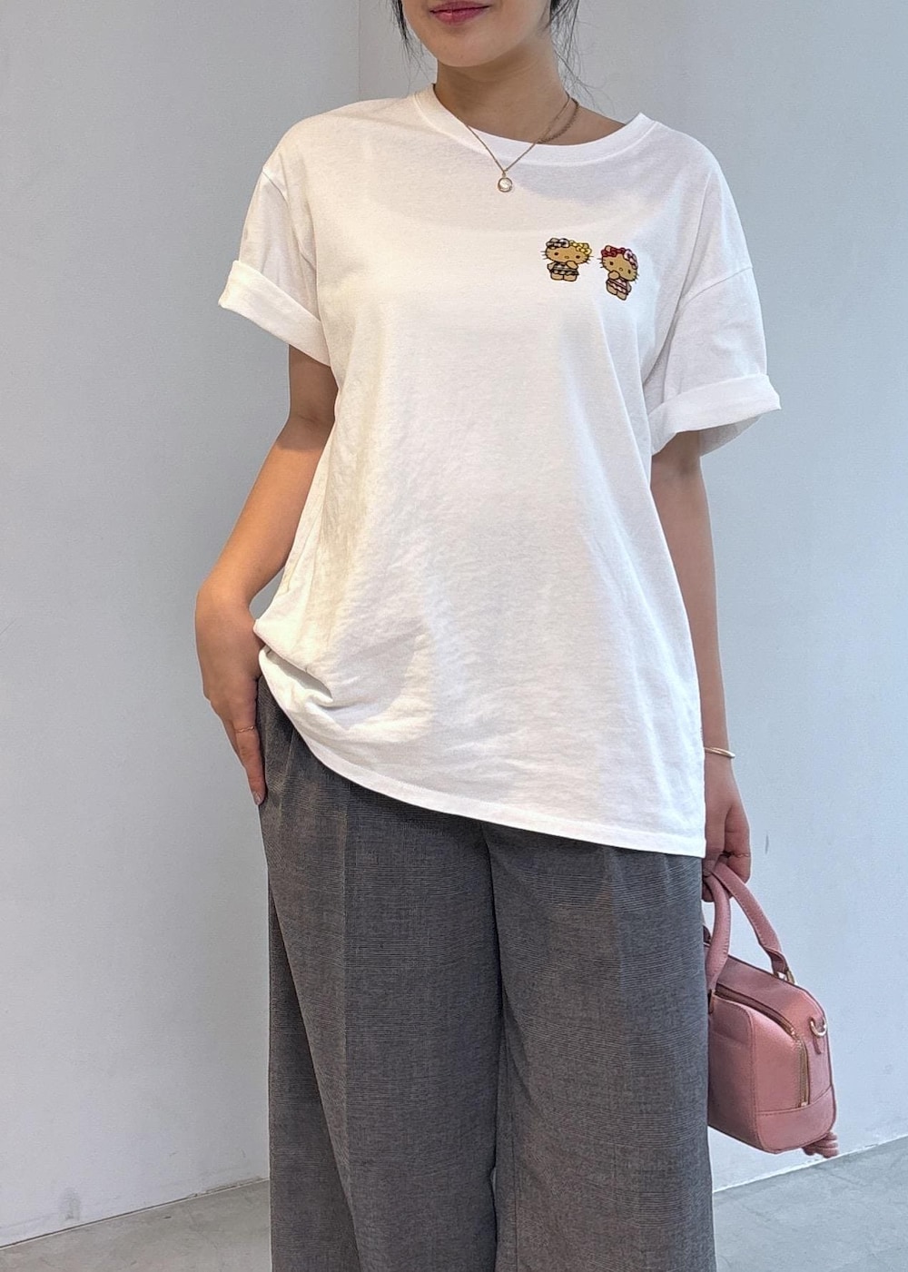 ピンク系のボストンバッグ、ブラック系のパンプス、ホワイト系のTシャツ/カットソーを着用したレディースの夏コーディネートの7枚目の写真
