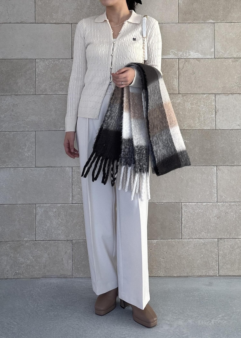 ホワイト系のハンドバッグ、ベージュ系のブーツ、ホワイト系のカーディガン/ボレロを着用したレディースの秋コーディネートの8枚目の写真