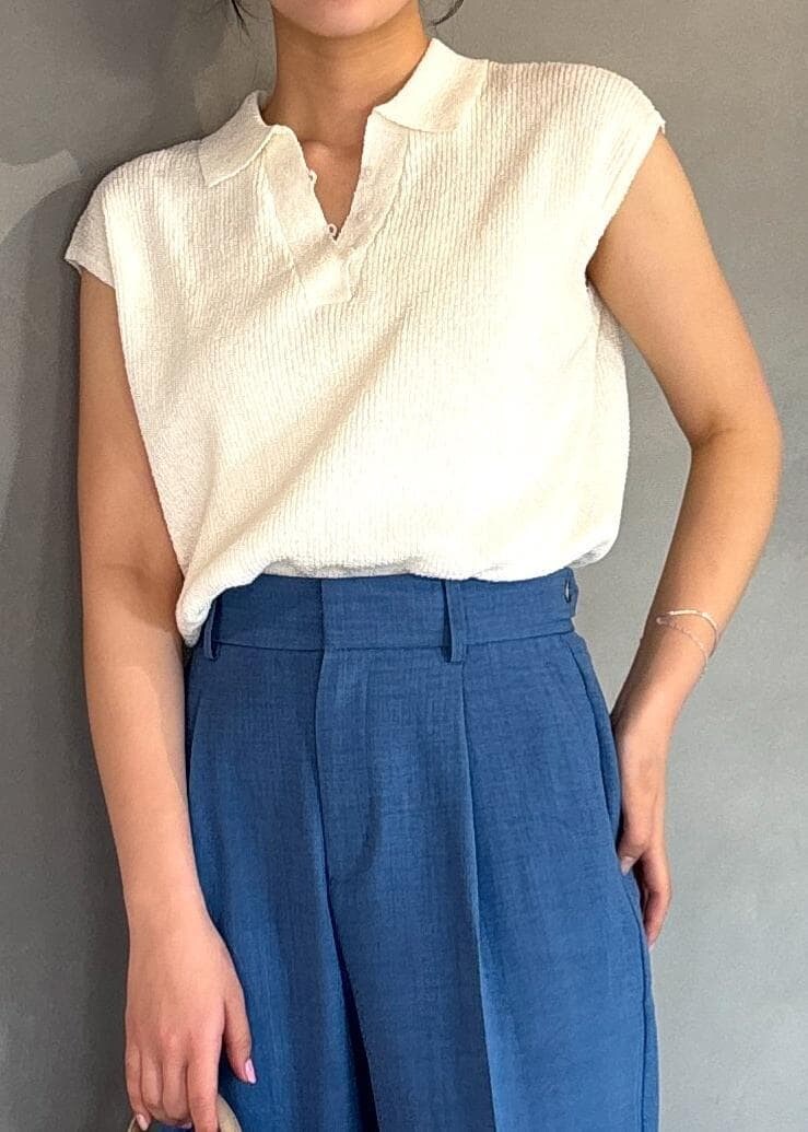 ホワイト系のミリタリージャケット、ブルー系のスラックス、ホワイト系のニット/セーターを着用したレディースの春コーディネートの3枚目の写真