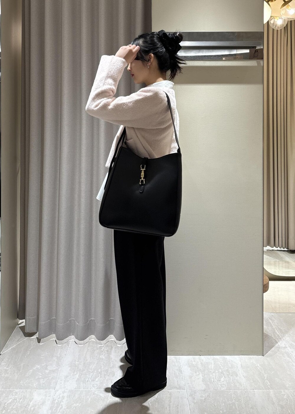 ホワイト系のシャツ/ブラウス、ピンク系のカーディガン/ボレロ、ブラック系のスラックスを着用したレディースの冬コーディネートの5枚目の写真
