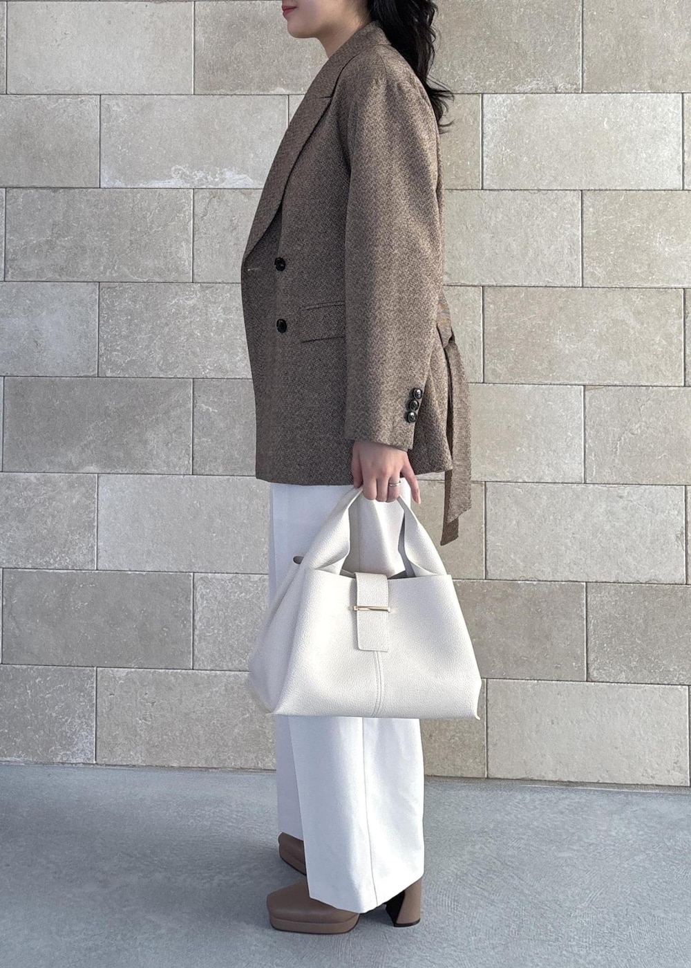 ホワイト系のハンドバッグ、ベージュ系のブーツ、ホワイト系のカーディガン/ボレロを着用したレディースの秋コーディネートの6枚目の写真