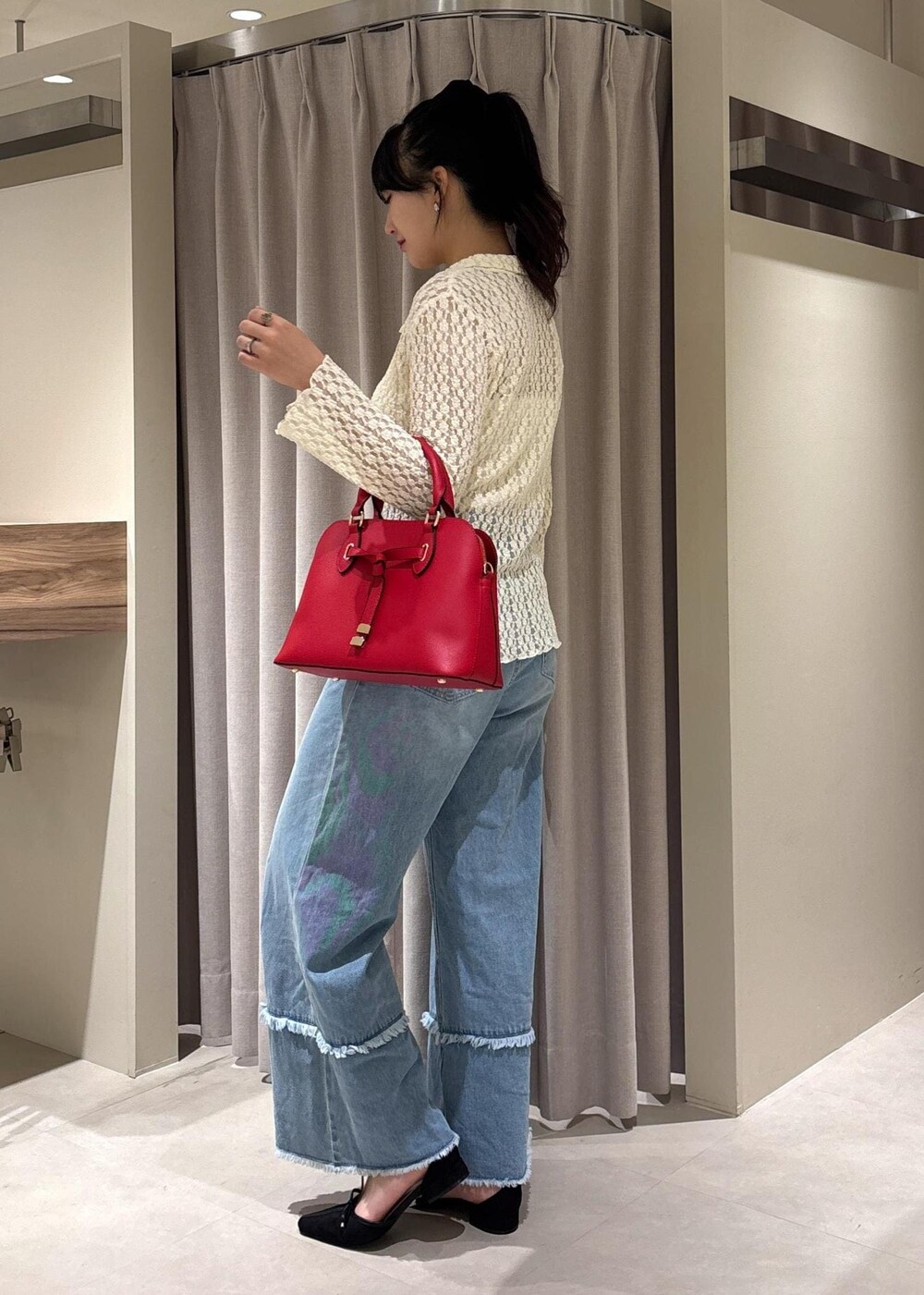 ブルー系のデニムパンツ、ブラック系のパンプス、ホワイト系のカーディガン/ボレロを着用したレディースの秋コーディネートの2枚目の写真