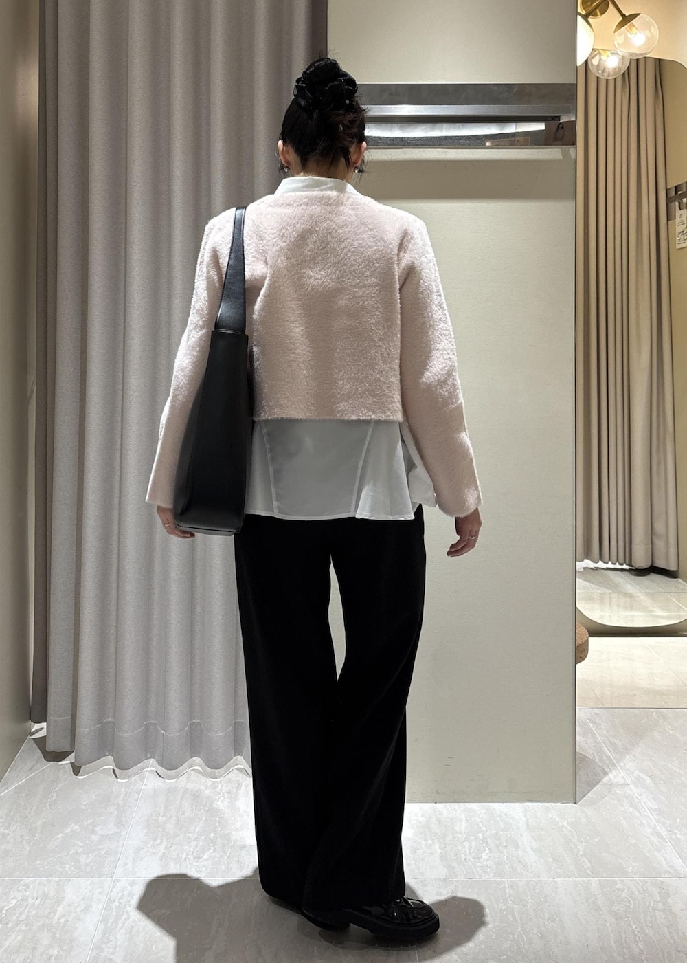 ホワイト系のシャツ/ブラウス、ピンク系のカーディガン/ボレロ、ブラック系のスラックスを着用したレディースの冬コーディネートの6枚目の写真