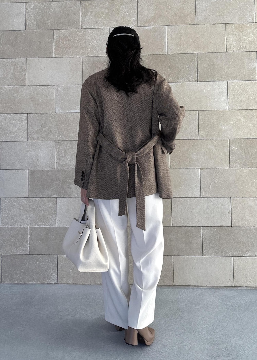 ホワイト系のハンドバッグ、ベージュ系のブーツ、ホワイト系のカーディガン/ボレロを着用したレディースの秋コーディネートの5枚目の写真