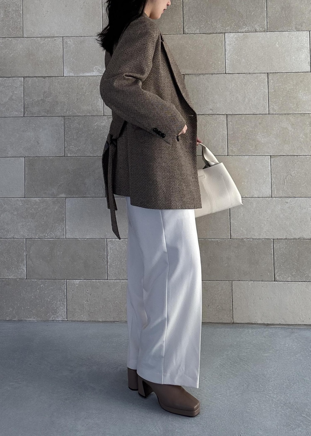 ホワイト系のハンドバッグ、ベージュ系のブーツ、ホワイト系のカーディガン/ボレロを着用したレディースの秋コーディネートの4枚目の写真
