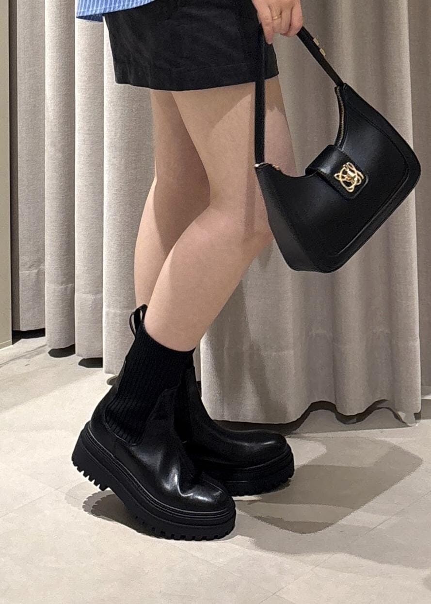 ブラック系のショルダーバッグ、ブラック系のブーツ、グレー系のその他パンツを着用したレディースの秋コーディネートの4枚目の写真