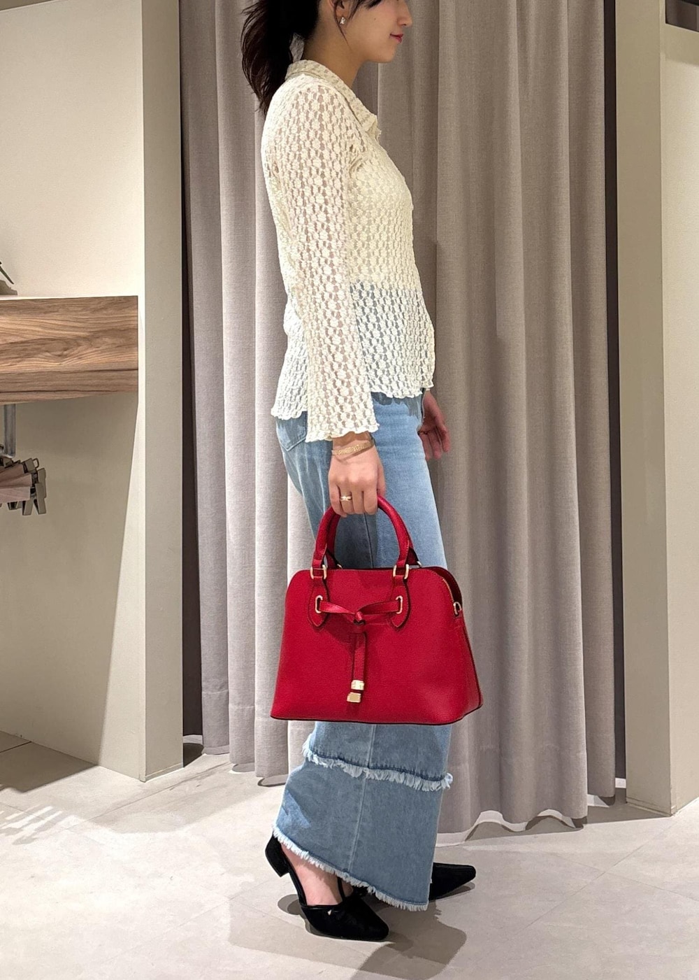 ブルー系のデニムパンツ、ブラック系のパンプス、ホワイト系のカーディガン/ボレロを着用したレディースの秋コーディネートの7枚目の写真