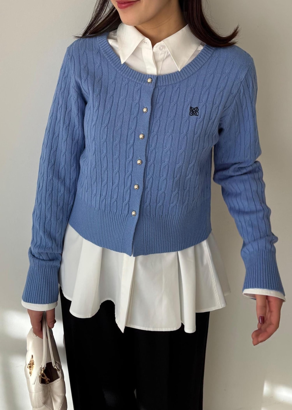 ブルー系のカーディガン/ボレロ、ホワイト系のシャツ/ブラウス、ブルー系のスラックスを着用したレディースの冬コーディネートの2枚目の写真