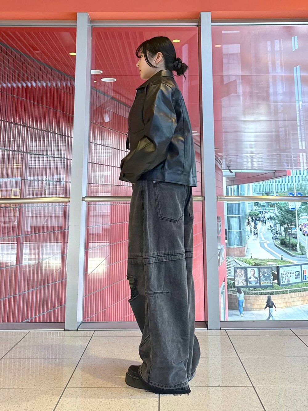 ブラック系のライダースジャケット、ホワイト系のTシャツ/カットソー、ブラック系のデニムパンツを着用したレディースの秋コーディネートの3枚目の写真