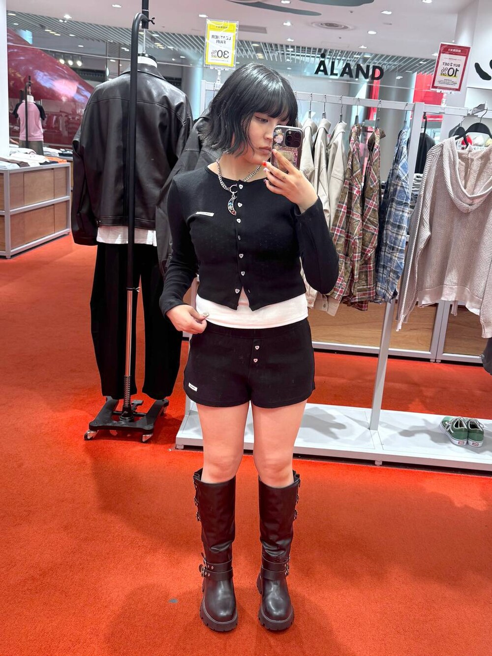 ホワイト系のキャミソール、ブラック系のブーツ、ブラック系のカーディガン/ボレロを着用したレディースの春コーディネートの2枚目の写真